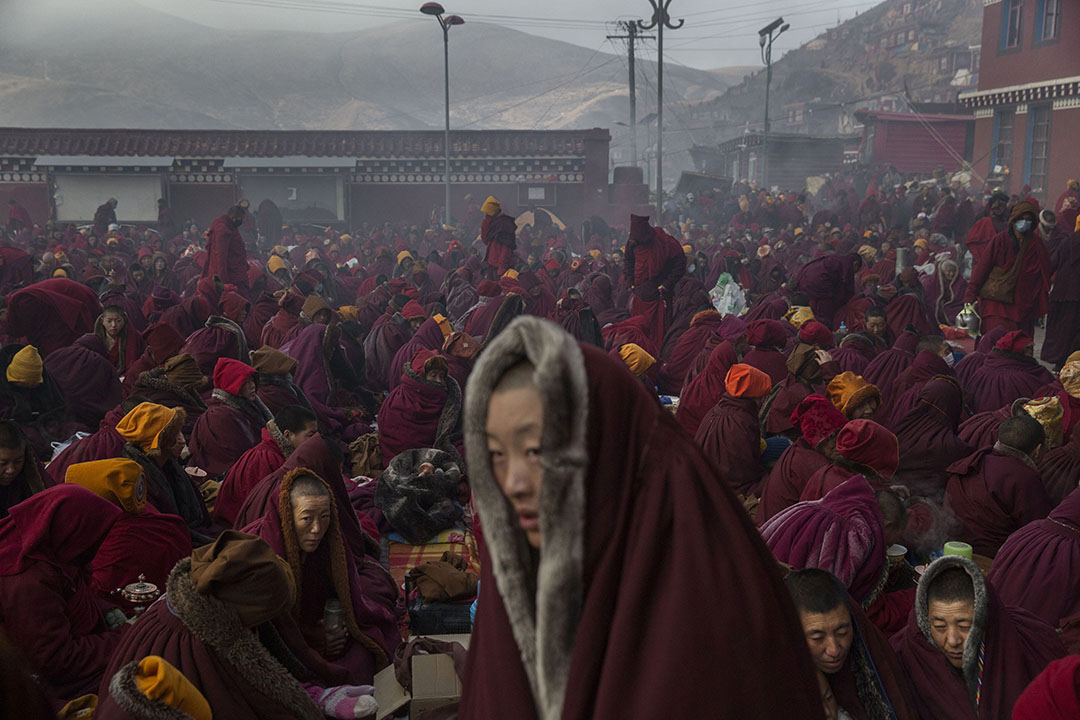 天气寒冷，喇嘛们披着厚厚的上衣，在佛学院里坐着。摄：Kevin Frayer/Getty Images