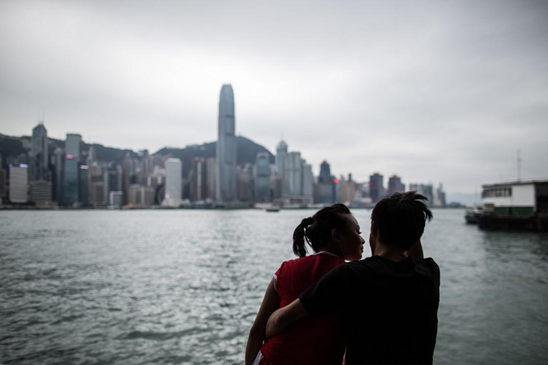 一對情侶在尖沙咀海旁談情。攝:ANTHONY WALLACE/AFP