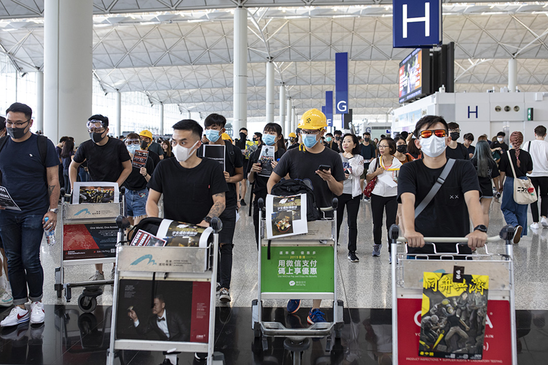 2019年8月12日,示威者在香港國際機場內示威,向旅客派發傳單及呼叫口號。