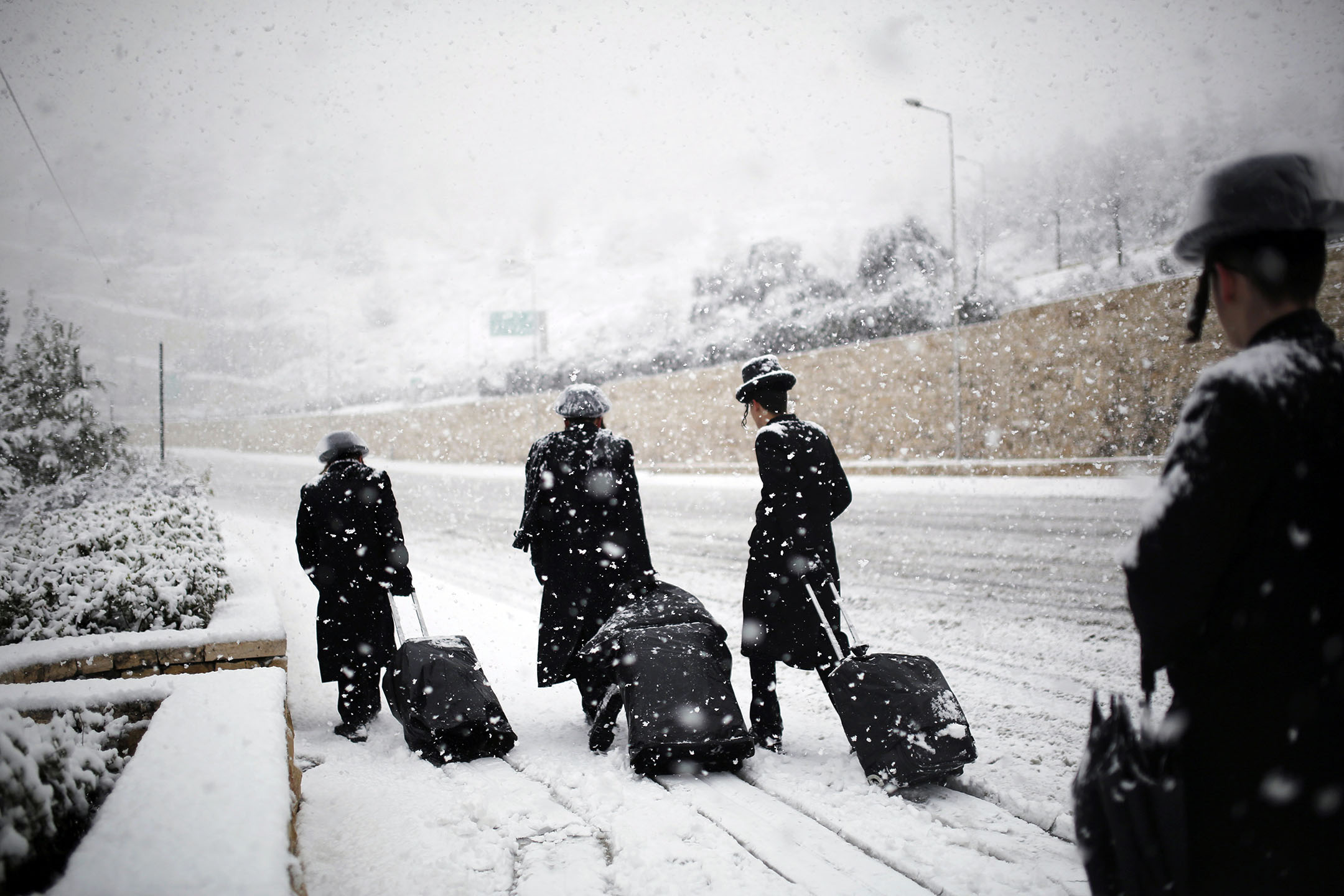 2013年12月12日，犹太男子在耶路撒冷积雪的道路上行走。摄：Amir Cohen/Reuters/达志影像